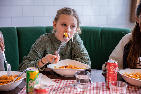 Flicka äter pasta i restaurang Tavolata